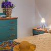 Dettaglio di camera con letto matrimoniale e lampada.
